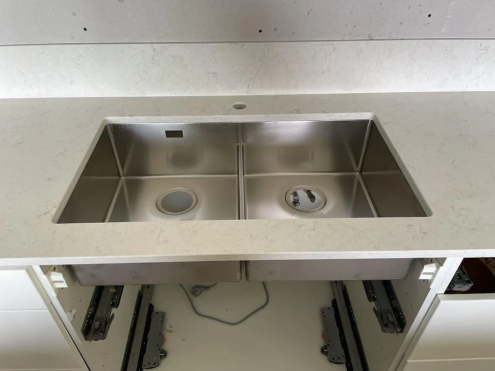 Underlimmad rostfri diskho i polerad Silestone Snowy Ibiza med lågt stänkskydd i kök i Nacka strand.