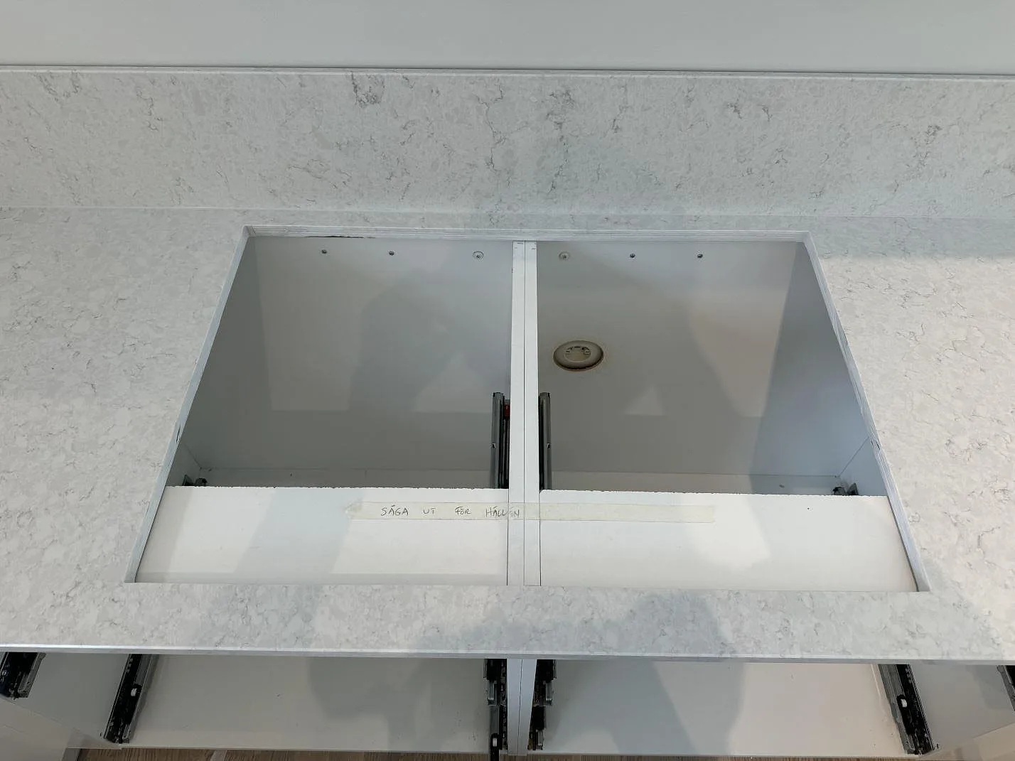 Detalj av rektangulär öppning i polerad Silestone Snowy Ibiza köksbänkskiva med stänkkant bakom i Nättraby.