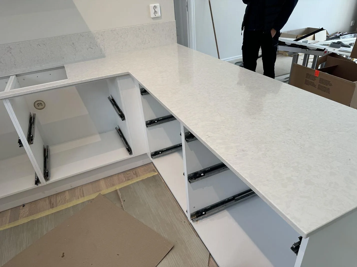 Polerad Silestone Snowy Ibiza köksbänkskiva på vita stommar, med halvö, öppen bänkrad och låg stänkkant i Nättraby.