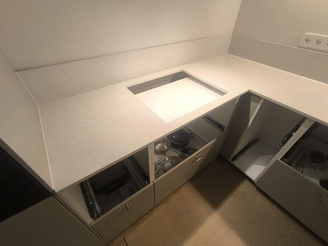 Hällöppning i polerad Silestone Snowy Ibiza, ljus kvartskomposit med diskret marmorering och stänkkant i Norrköping.
