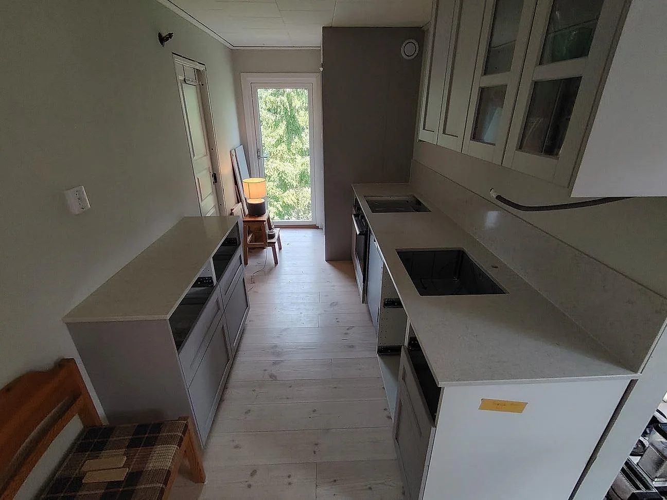 Polerad köksbänkskiva i Silestone Snowy Ibiza med två bänkytor, diskho, häll och stänkskydd i ett kök i Nyköping.