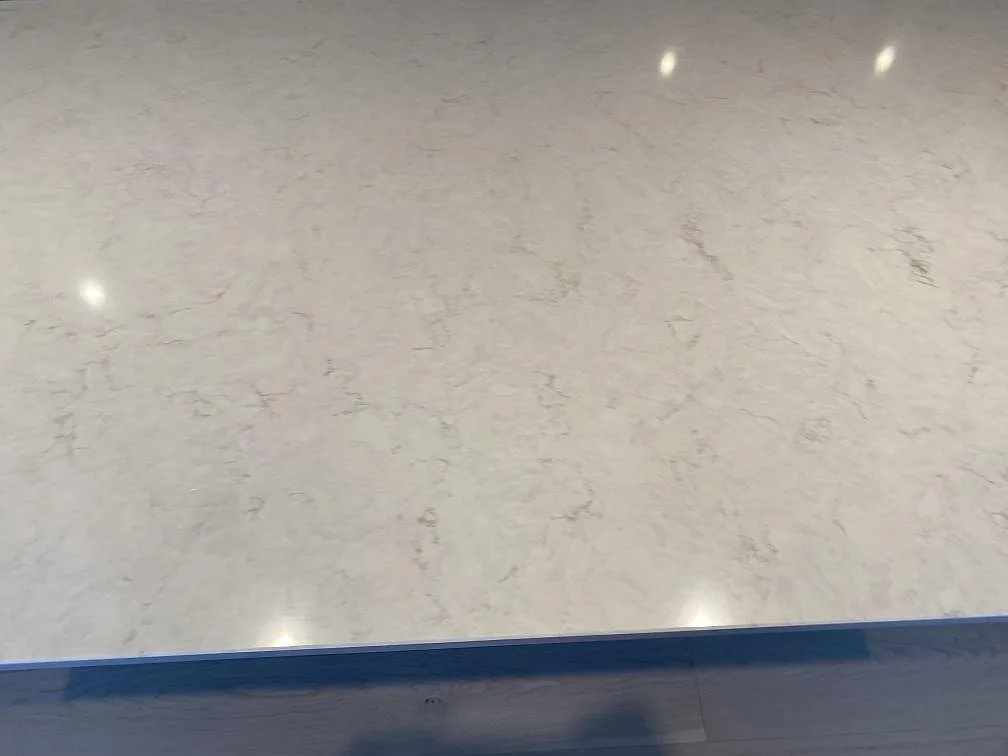 Ovanifrån på den polerade köksön i vit Silestone Snowy Ibiza med diskret grå ådring i ett kök i Österskär.