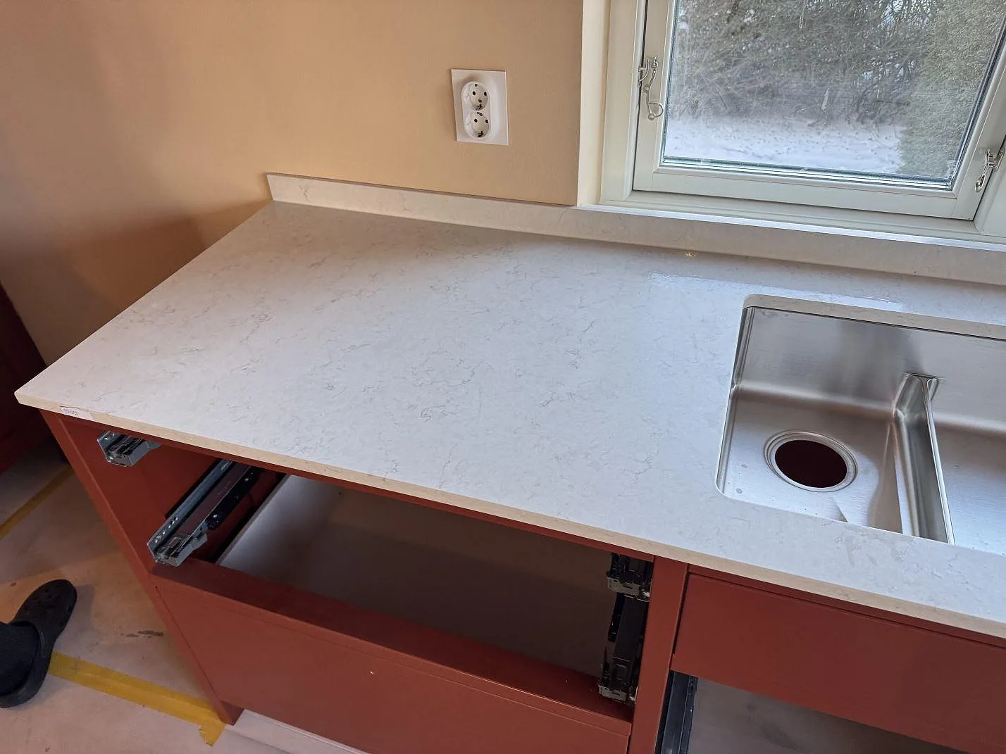 Vit Silestone Snowy Ibiza köksbänkskiva i matt Mocka med rostfri diskho och fönster, fotograferad under montering i Östra Vemmerlöv.