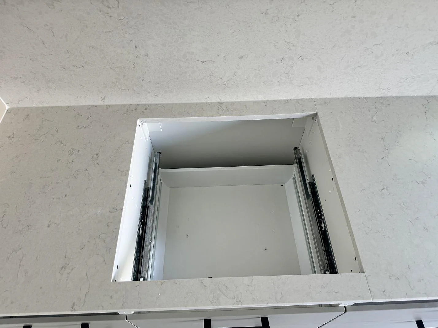 Ovanvy av hälluttag i polerad Silestone Snowy Ibiza köksbänkskiva med matchande stenskydd i Ojersjo.