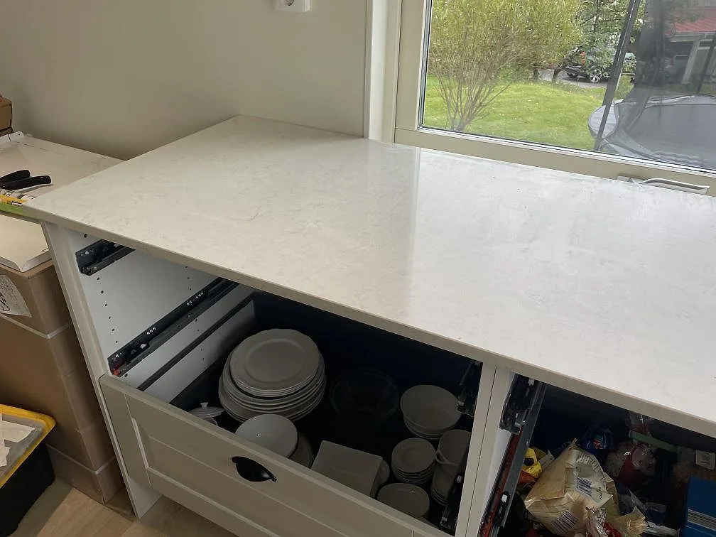 Närbild på polerad Silestone Snowy Ibiza över öppen köksstomme och fönsterljus i Olofstorp.
