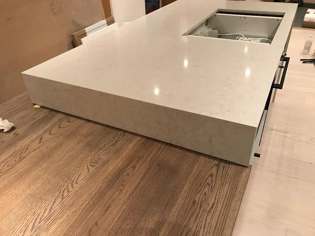 Köksö i Silestone Snowy Ibiza med tjock helsidad stenkant och polerad yta i ett kök i Onsala.