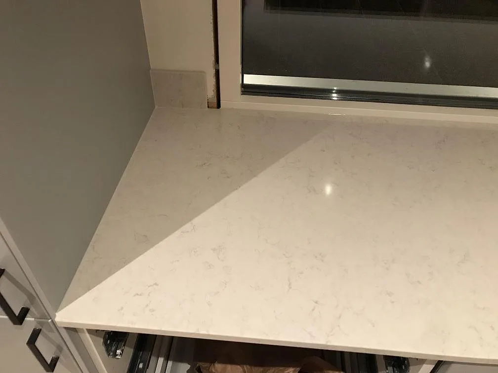 Bänkskiva i Silestone Snowy Ibiza mot fönstret med diskret grå ådring och polerad yta i ett kök i Onsala.