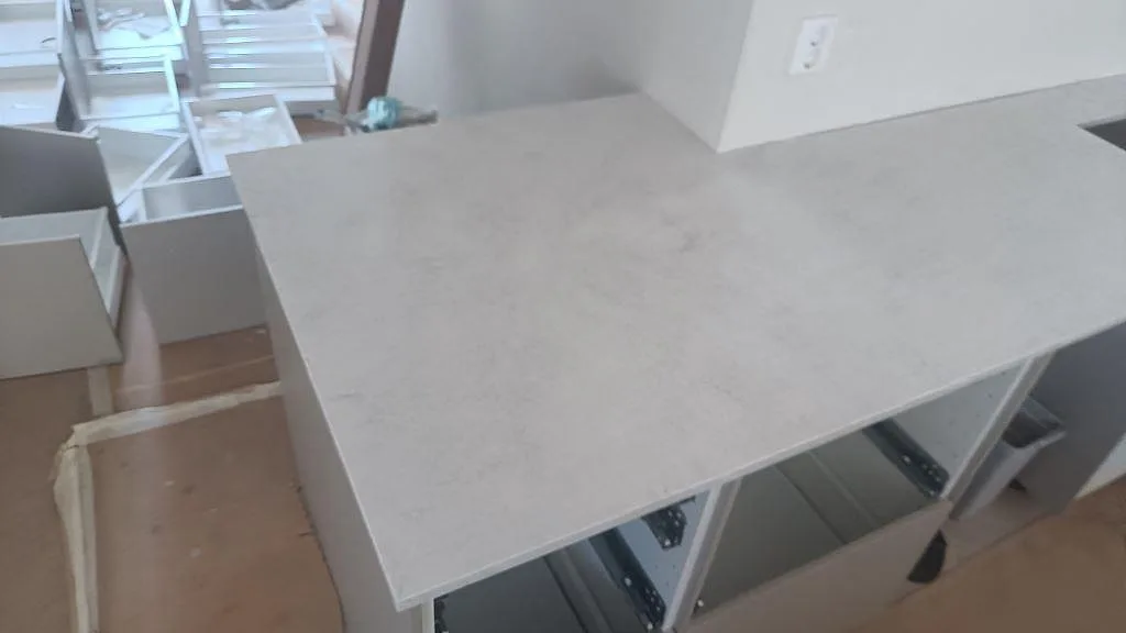 Närbild av den polerade Silestone Snowy Ibiza ytan i ljus kvartskomposit på köksbänkskivan under montering i Osby.