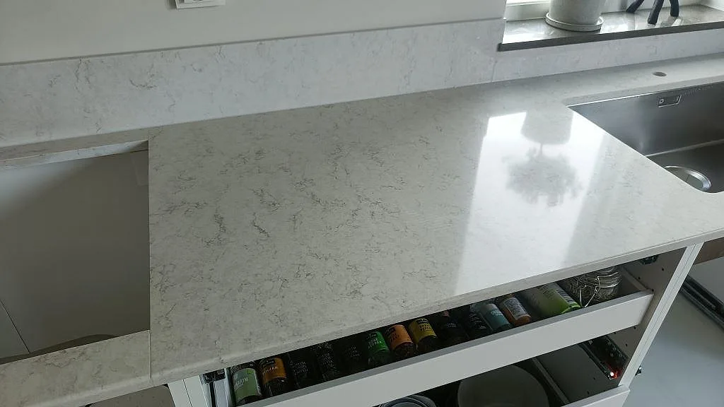 Polerad bänkskiva i Silestone Snowy Ibiza med underlimmad rostfri diskho i ett kök i Oxie.