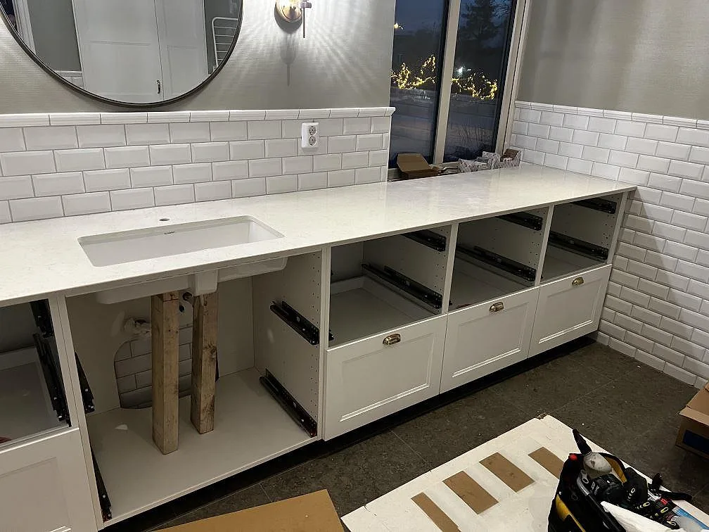 Badrumsbänkskiva i vit Silestone Snowy Ibiza, polerad, med underlimmat handfat och vitt fasat kakel i Röke.