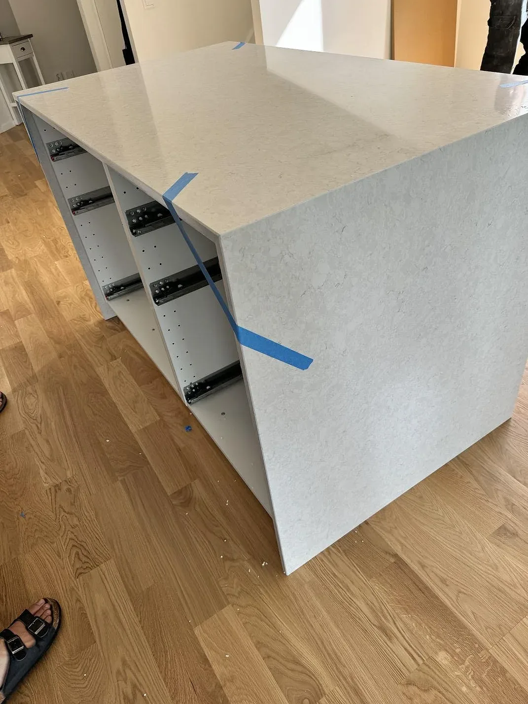 Sidovy av polerad Silestone Snowy Ibiza på arbetsyta med öppen stomme, trägolv och ljus ådring i Rydebäck.