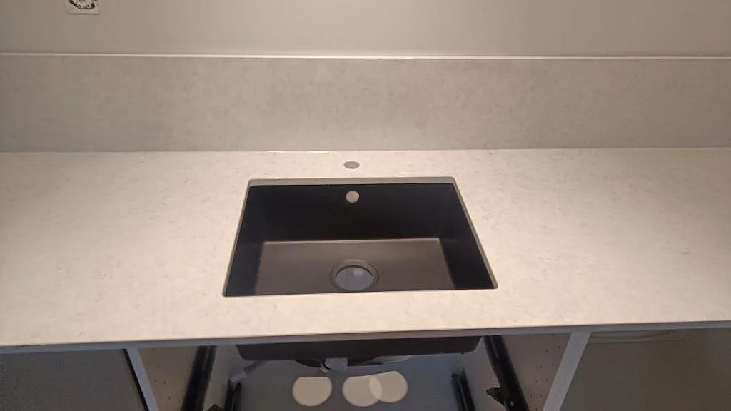 Diskhozon i en polerad köksbänkskiva av Silestone Snowy Ibiza med matchande stänkkant i Rydebäck.