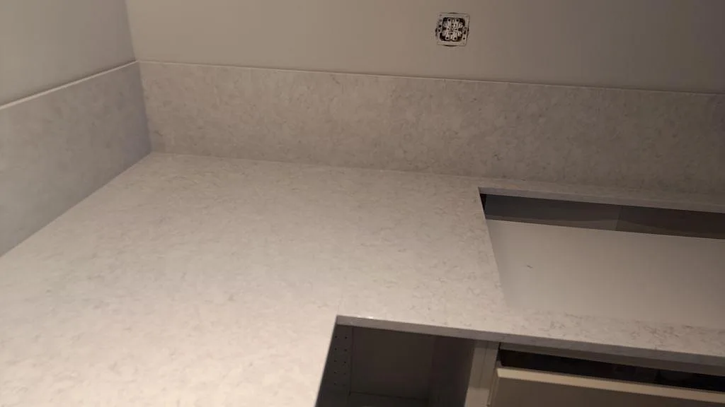 Ytdetalj av polerad Silestone Snowy Ibiza med ljus ådring och låg stänkkant i köket i Rydebäck.