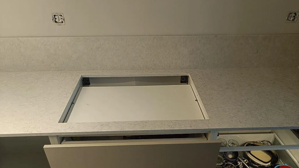 Hällöppning i polerad Silestone Snowy Ibiza med matchande låg stänkkant i ett kök i Rydebäck.
