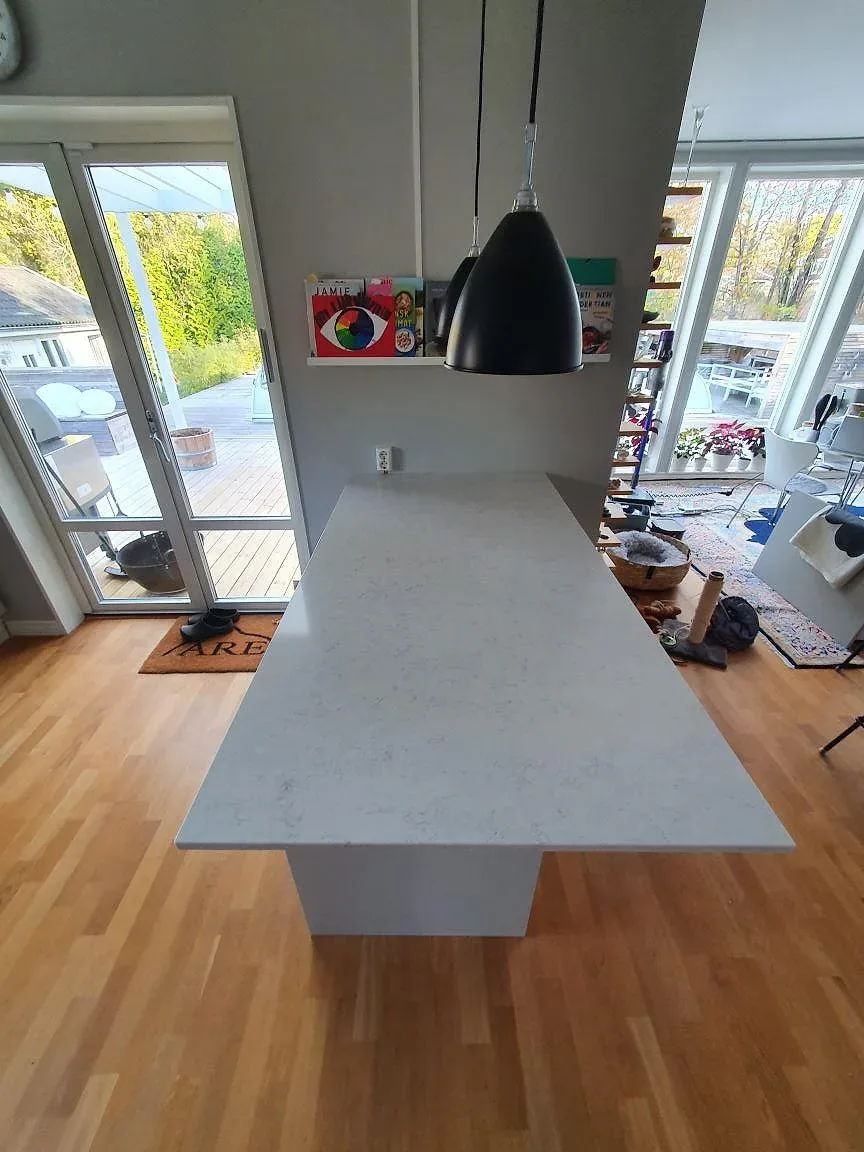 Köksö i ljus Silestone Snowy Ibiza, polerad, med diskret grå ådring i ett kök i Saltsjö-Boo.