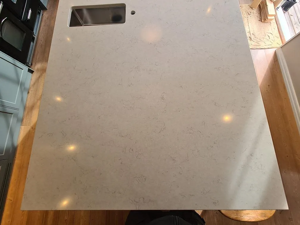 Polerad köksö i Silestone Snowy Ibiza komposit med rostfri underlimmad diskho i Saltsjö Boo.