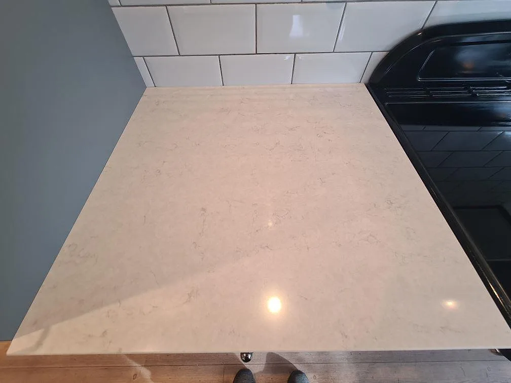Perimeterbänkskiva i polerad Silestone Snowy Ibiza komposit vid fristående spis i Saltsjö Boo.