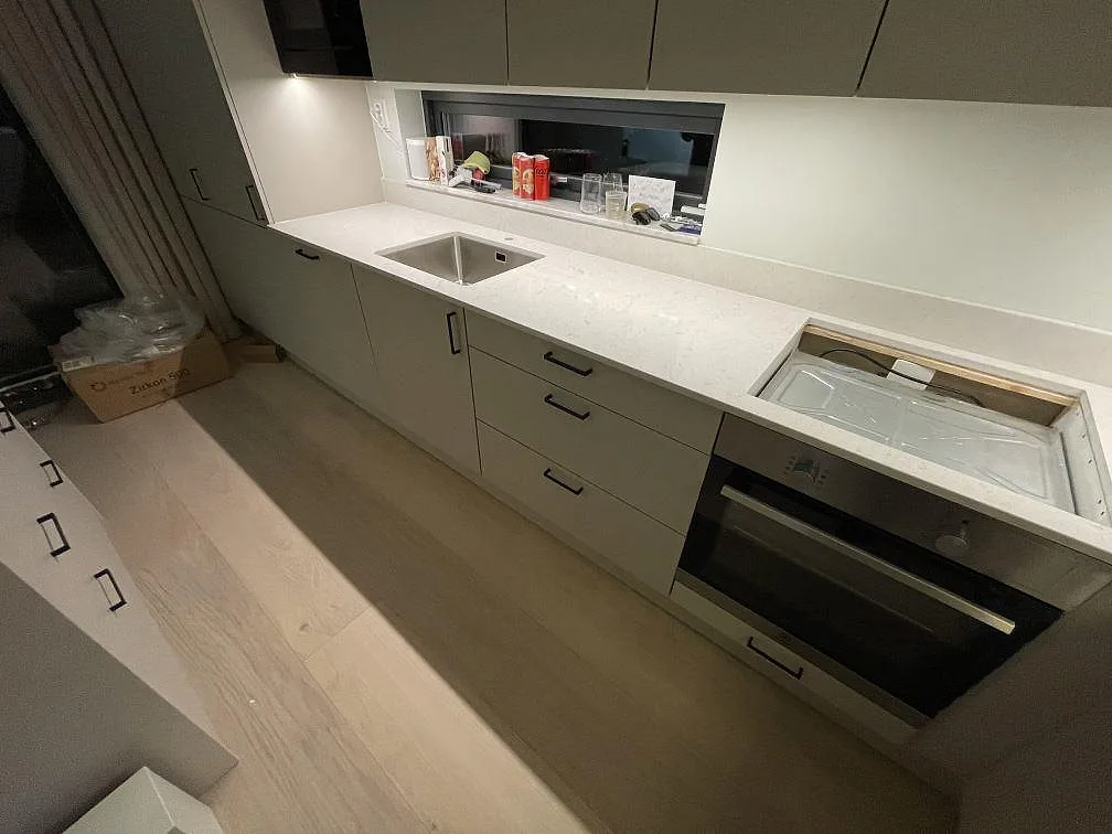Köksbänkskiva i polerad Silestone Snowy Ibiza med synlig diskho, förberett hällurtag och stänkskydd i Saltsjö Boo.
