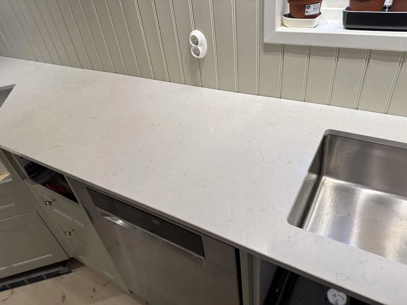 Bänkskiva i Silestone Snowy Ibiza komposit med rostfri diskho och utskuret blandarhål i Sjuntorp.