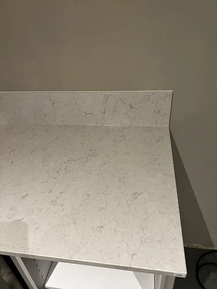 Närbild på polerad Silestone Snowy Ibiza med ljusgrå ådring, bänkskiva och låg stänkkant i Skummeslövsstrand.