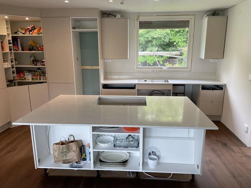 Polerad köksö i Silestone Snowy Ibiza med förberett rektangulärt urtag och bakre bänkskiva under fönster i ett kök i Sollentuna.