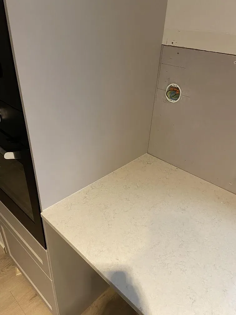 Detalj av polerad Silestone Snowy Ibiza komposit med ljus ådring och utskärning i köksbänkskiva i Staffanstorp.