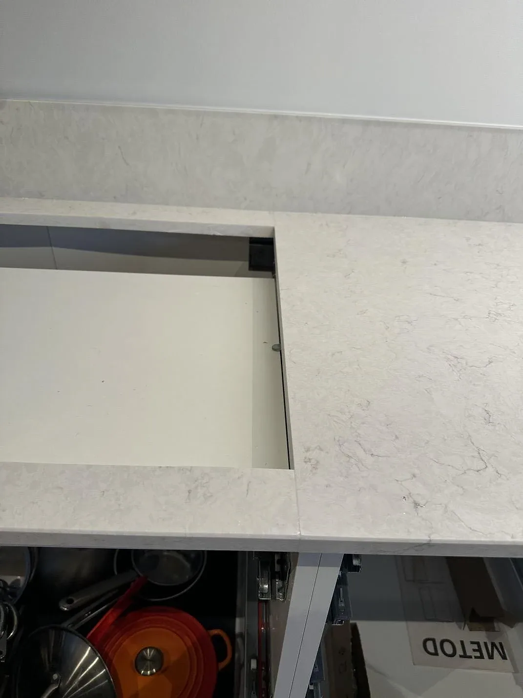 Närbild av hällurtag i polerad Silestone Snowy Ibiza köksbänkskiva med öppen stomme under montering i Staffanstorp.