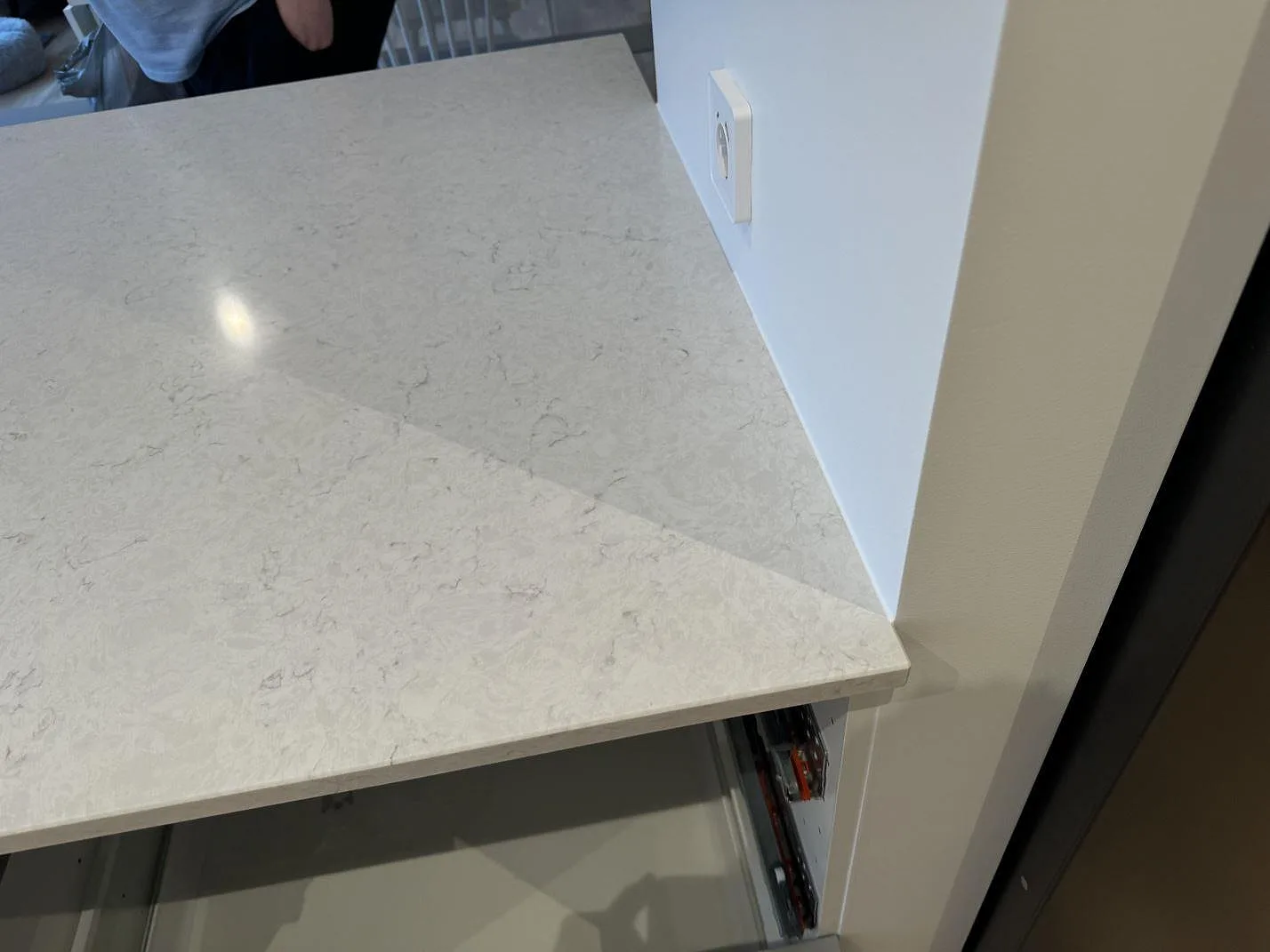 Kantdetalj på polerad Silestone Snowy Ibiza bänkskiva med ljus ådring vid vägg i Staffanstorp.