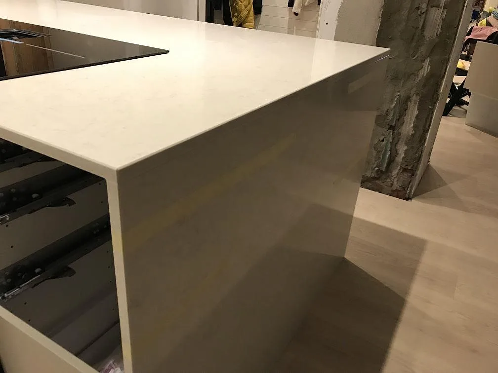 Vinklad halvö i polerad Silestone Snowy Ibiza med synlig kantprofil och öppna stommar i ett kök i Steninge.