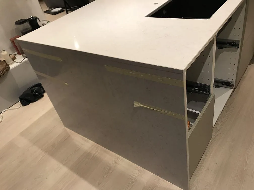 Halvö i polerad Silestone Snowy Ibiza med diskhourtag och maskerade kanter under montering i Steninge.