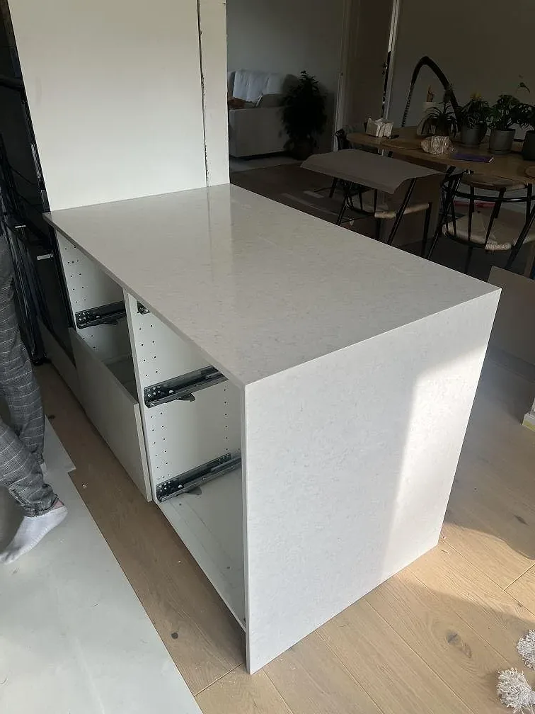 Polerad köksbänkskiva i Silestone Snowy Ibiza komposit med ljus ådring på en bänkdel under montering i Stockholm.