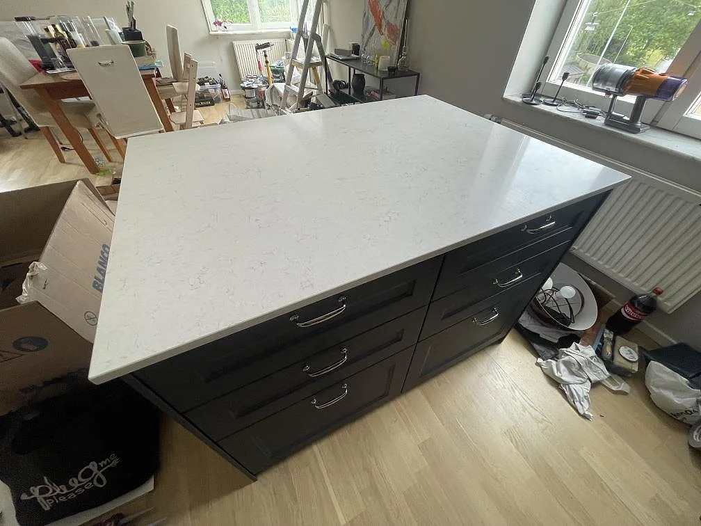 Separat köksö med polerad Silestone Snowy Ibiza i vit komposit med mjuk grå ådring i Stockholm.