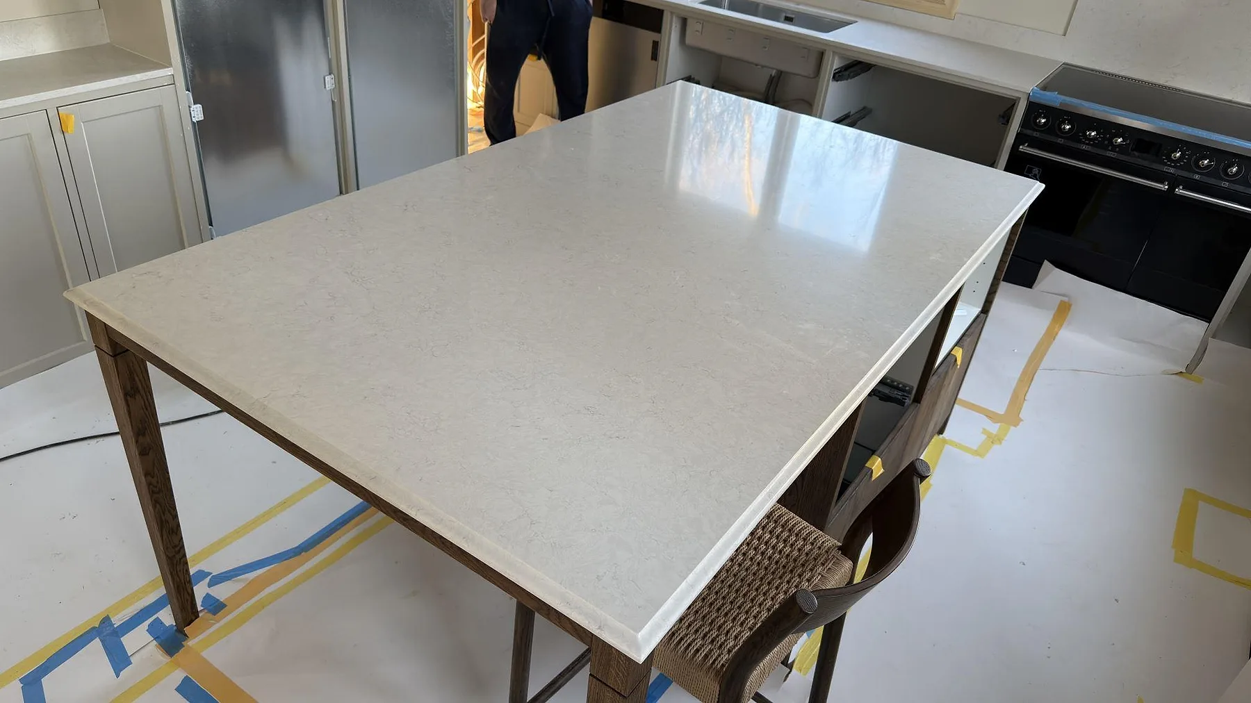 Närbild på polerad Silestone Snowy Ibiza som stenskiva på träunderrede i ett kök i Stockholm, med ljus ådring och blank yta.
