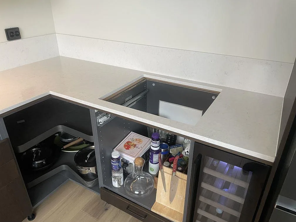 Närbild på den polerade ytan i Silestone Snowy Ibiza vid hörnet med urtag för häll och en hörnkarusell i ett kök i Stockholm.