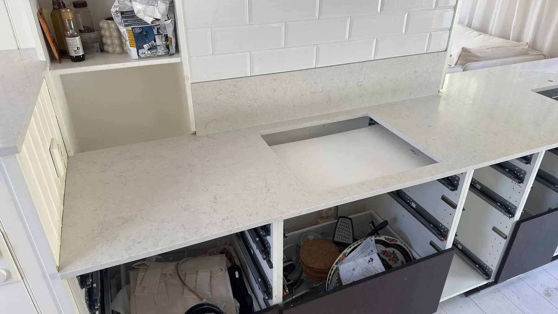 Närbild på den polerade ytan i Silestone Snowy Ibiza med det öppna hålurtaget för hällen, ljus kvartskomposit i ett kök i Stockholm.