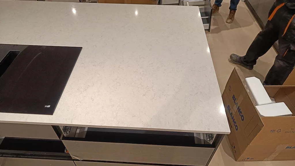 Hörn av köksö i polerad Silestone Snowy Ibiza som visar 20 mm tjocklek och kant i ett kök i Svedala.
