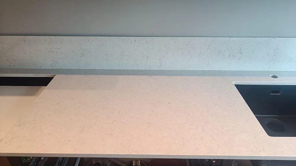 Köksbänk i polerad Silestone Snowy Ibiza med hällöppning, diskho och låg stänkkant i Svedala.