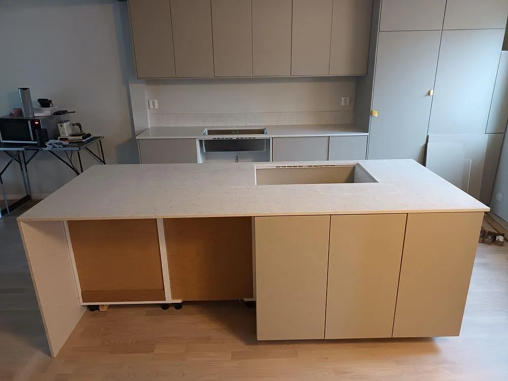 Bänkrad i vit Silestone Snowy Ibiza längs väggen med urtag för diskho, polerad yta, fotad under monteringen i ett kök i Täby.