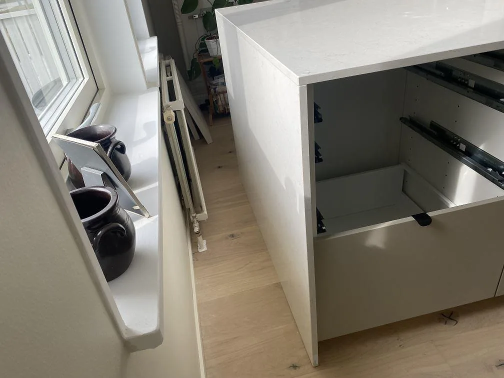 Köksbänkskiva i polerad Silestone Snowy Ibiza kvartskomposit med synlig stensida vid öppna köksstommar i Tingsryd.