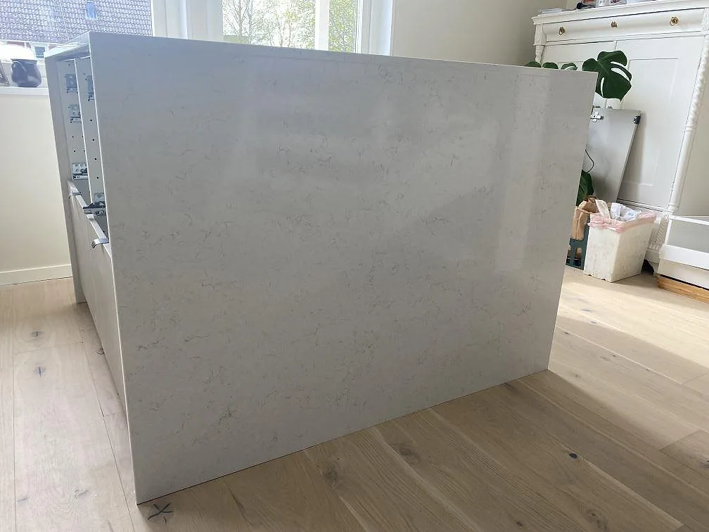 Sidovy av köksbänk i polerad Silestone Snowy Ibiza kvartskomposit med ljus ådring i köket i Tingsryd.