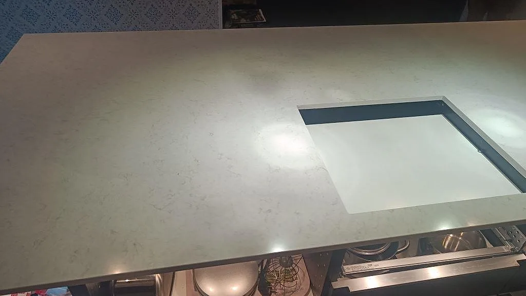 Närbild av polerad Silestone Snowy Ibiza, kvartskomposit, runt ett rektangulärt urtag i köksbänkskivan i Tomelilla.
