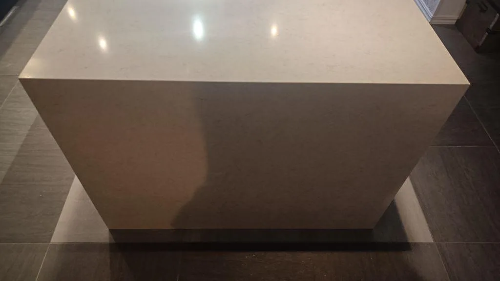 Frontvy av köksö med polerad Silestone Snowy Ibiza, ljus kvartskomposit med neddragen stenkant i Tomelilla.