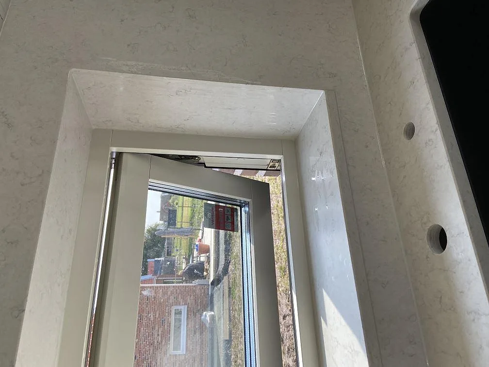 Stenklädd fönstersmyg i vit Silestone Snowy Ibiza kvartskomposit i ett kök i Trelleborg.