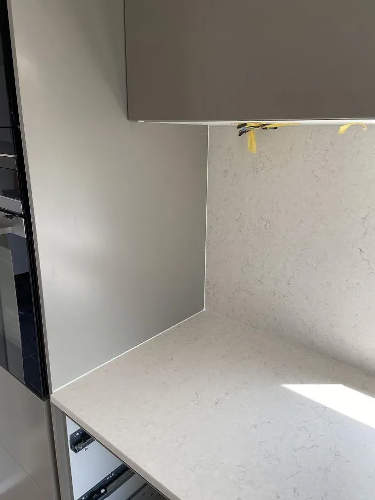 Vit Silestone Snowy Ibiza bänkskiva med uppvikt stänkkant i ett kök i Trelleborg, matt yta.