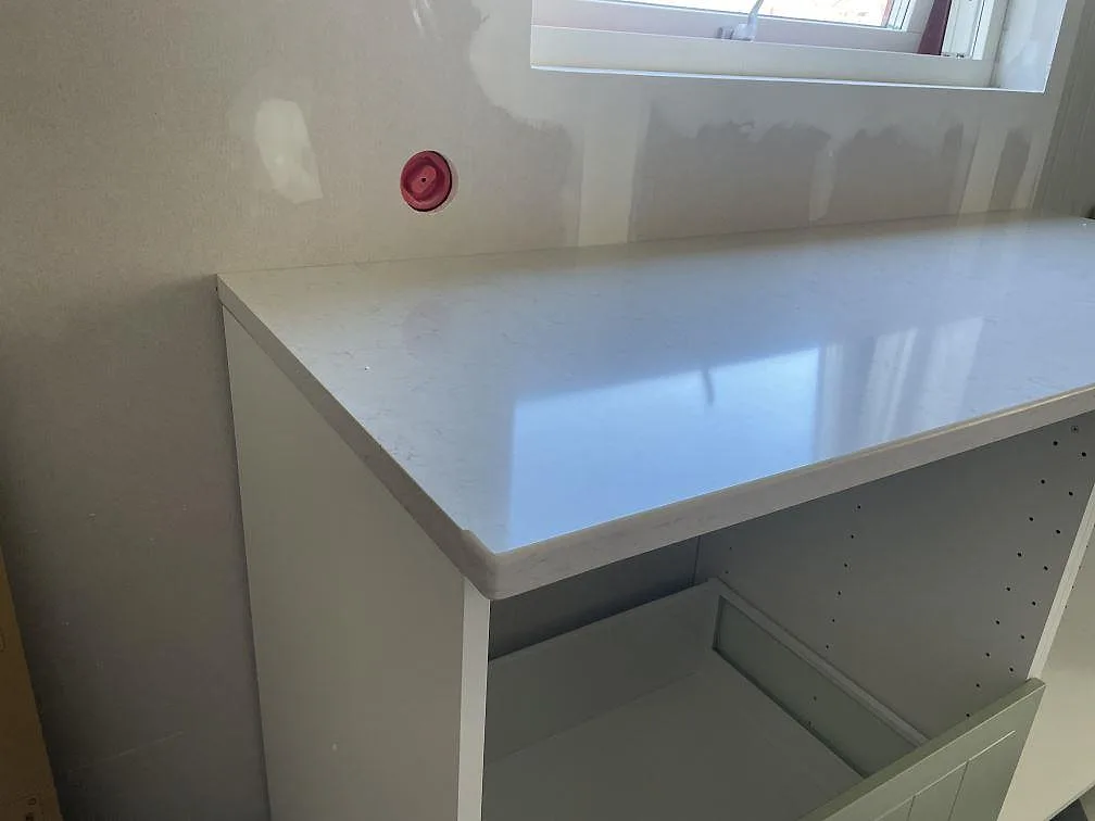 Närbild på polerad Silestone Snowy Ibiza med spegelblank yta på halvön i ett kök i Trollhättan.