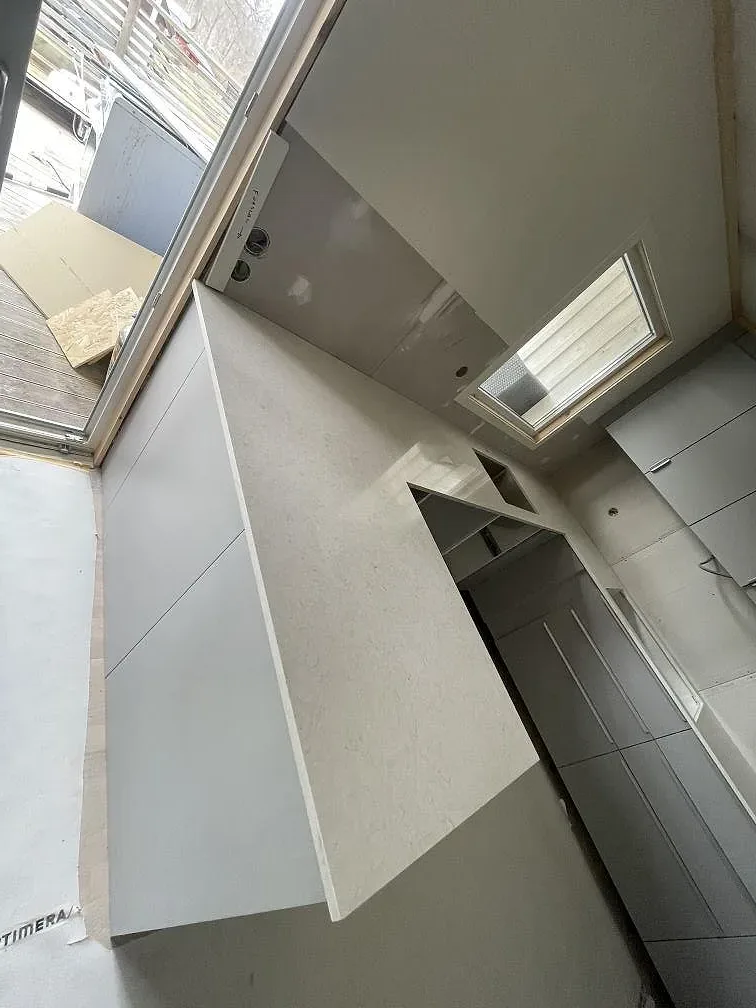 Närbild på den vita Silestone Snowy Ibiza-bänkskivans yta och mjuka ådring på köksön i ett kök i Ulricehamn.