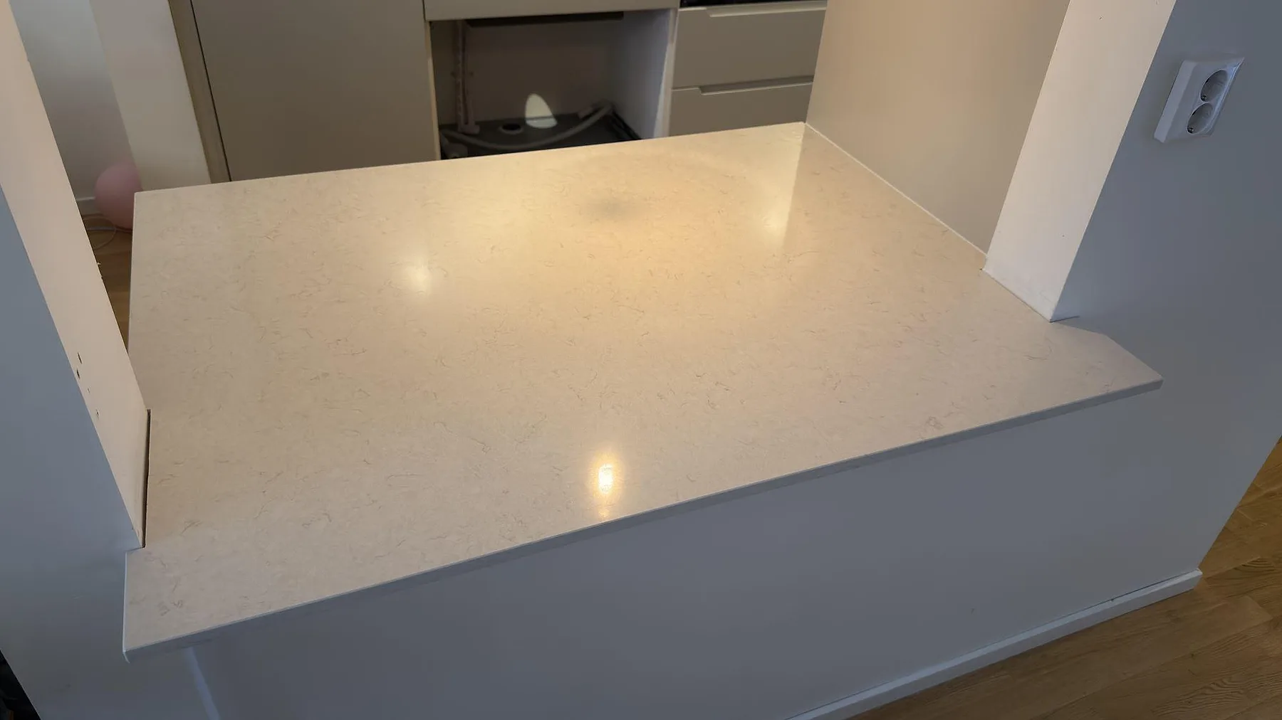 Närbild av polerad Silestone Snowy Ibiza i vit kvartskomposit på monterad serveringsskiva med diskret ådring i Upplands Väsby.