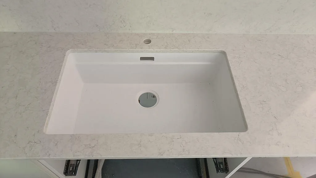 Vit underlimmad diskho infälld under polerad Silestone Snowy Ibiza med ljus grå ådring i Västra Frölunda.