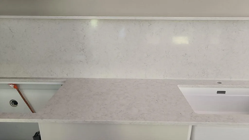 Polerad Silestone Snowy Ibiza med vit diskho, hälluttag och högt stänkskydd under köksmontering i Västra Frölunda.