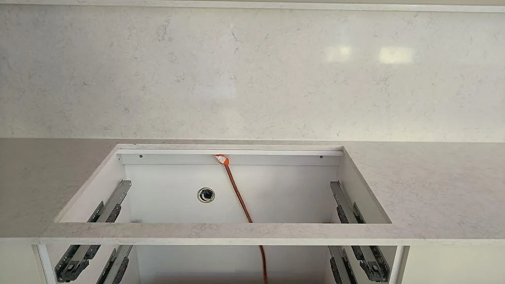 Hälluttag i polerad Silestone Snowy Ibiza framför matchande stänkskydd och öppna köksstommar i Västra Frölunda.